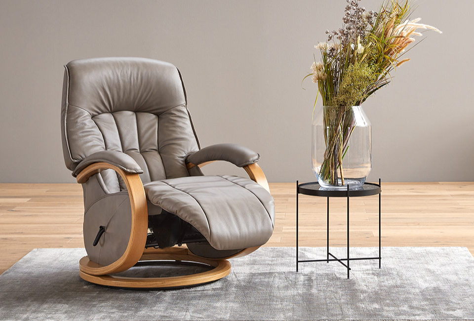 Beautifully designed with comfort and functionality in mind.

Like all Himolla upholstered furniture, the Mosel chair with wooden swivel ring combines stylish design with exceptional everyday comfort. The manual adjustment system allows you to tailor your seating position with ease - simply use the loop and gas spring mechanism to adjust the backrest, while body movement gently changes the position of the leg rest.

The adjustable headrest tilt adds even more personalised comfort, and the elegant wooden swivel ring allows for smooth 360&deg; movement. For additional seating height, an optional extra ring is also available to raise the chair by a further 2.5 cm.
